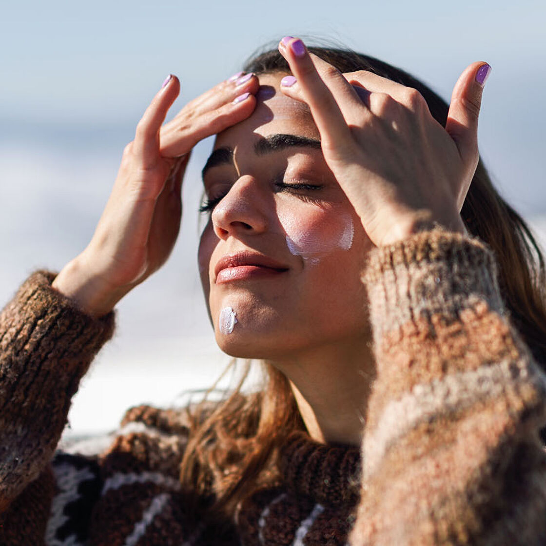 menina a pôr creme na cara